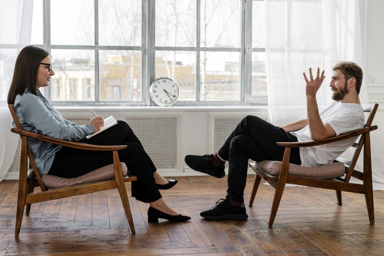 Ein Therapeut führt eine Beratungssitzung mit einem männlichen Patienten zur Unterstützung seiner psychischen Gesundheit.